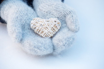 Female hands in mittens with heart, close-up