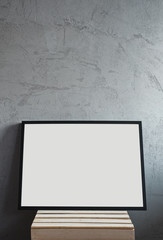 Empty poster frame and concrete wall in an apartment. 