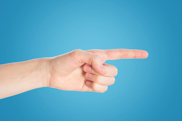 Pointing gesture. Female hand shows index finger on a white background isolate