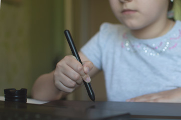 child draws on a graphic tablet