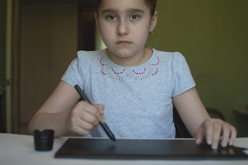 child draws on a graphic tablet