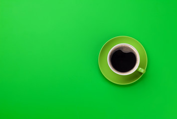 Green coffee cup over green background