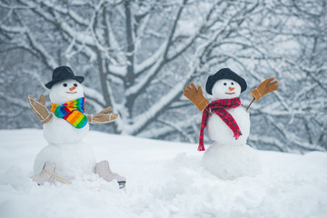 Snowman on a background snow-covered fir branches. Snowman in snow forest. Snowmen. Snowman isolated on snow background. Snowman and snow day.