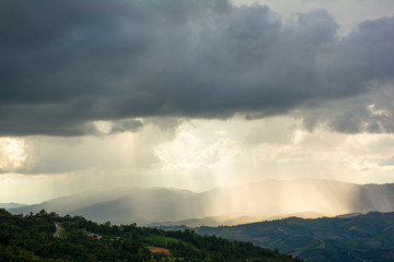 Heavy dark storm raining clouds over the sky above mountain range.
