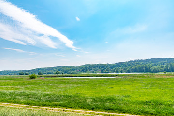 View over the Elbauen in Lower Saxony, Germany. You see a landscape with meadows, trees and the river Elbe.