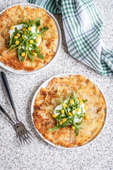 Potato rosti with corn and rocket salad served on a gray background. Traditional swiss dish