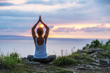 Caucasian woman practicing yoga at seashore