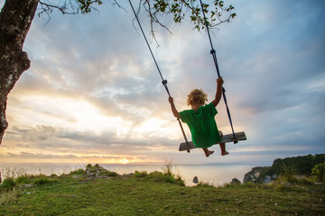 The back of the boys Swings are playing on the beach