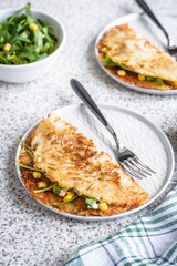 Potato rosti with corn and rocket salad served on a gray background. Traditional swiss dish