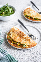 Potato rosti with corn and rocket salad served on a gray background. Traditional swiss dish