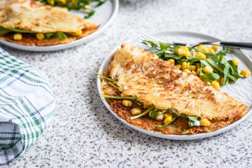 Potato rosti with corn and rocket salad served on a gray background. Traditional swiss dish