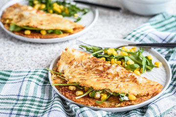 Potato rosti with corn and rocket salad served on a gray background. Traditional swiss dish
