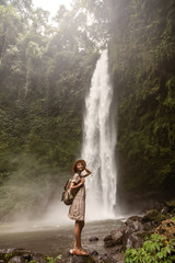 Fototapeta na wymiar Woman near Nung Nung waterfal on Bali, Indonesia