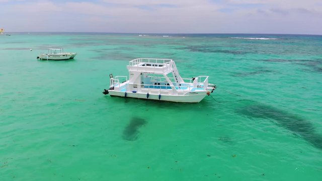 Aerial revolving shot of a boat anchored in shallow waters in Dominicana, an island in Caribbean