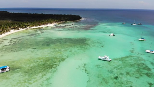 Aerial wide angle panning shot of small fishing and motor boats anchored at Dominicana, an island in the Caribbean