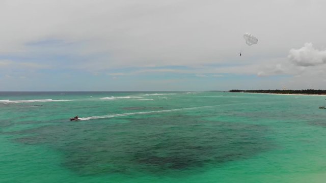 Aerial drone shot of a person parasailing at Dominican islan beach during day time