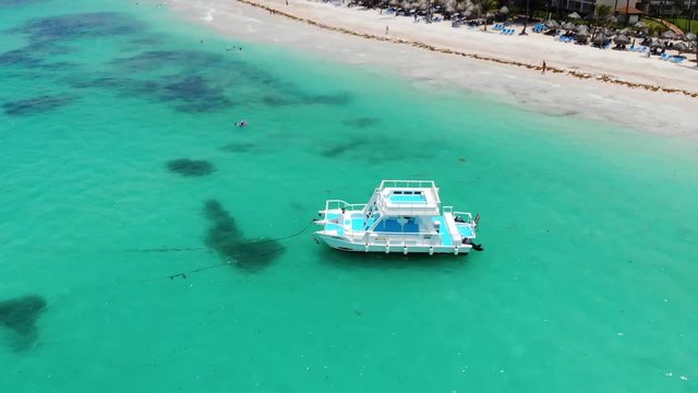 Aerial revolving shot of a boat anchored in shallow waters in Dominicana, an island in Caribbean