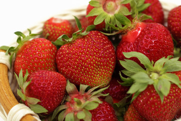  strawberries in a wicker basket on a white background