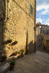 Naklejka premium A typical narrow street in Cortona historic center. Cortona is a beautiful medieval town in Tuscany, Italy