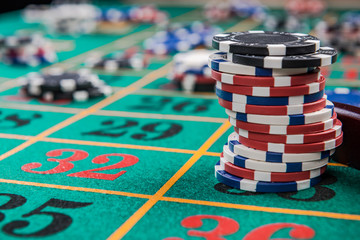 Stack of casino chips on green felt roulette table