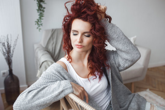 Closeup portrait of young beautiful redhaired woman. Redhead female indoors. Beauty portrait of attractive lady at home with free space.