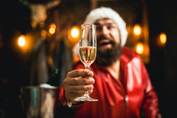 A bearded Santa in the background is offering a glass of champagne on camera. Сorporate holidays service.