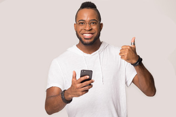 African guy happy smartphone user showing thumbs up studio shot