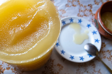 The shifting of honey from a larger container into a bowl.