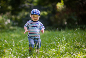 little cute baby is walking on the grass