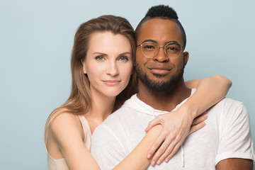 Obraz premium Young caucasian woman embracing black man for photoshoot.