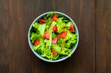 Salmon Poke Salad in blue bowl on wooden background. The concept of organic products.