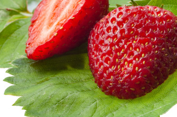 Fresh and half cut strawberries with leaves in macro