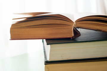 Open book, hardback books on bright colorful background.
