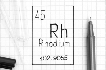 Handwriting chemical element Rhodium Rh with black pen, test tube and pipette.
