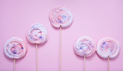 Pink meringues with glitter on a pink background