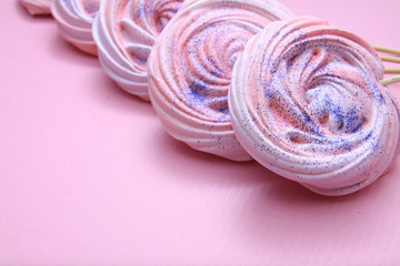 Pink meringues with glitter on a pink background