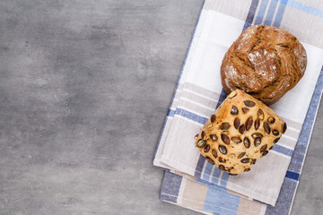 Gold rustic crusty loaves of bread and buns on wooden background. Still life captured from above top view, flat lay.
