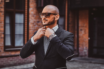 Young sucessful businesman is posing for photographer near his office.