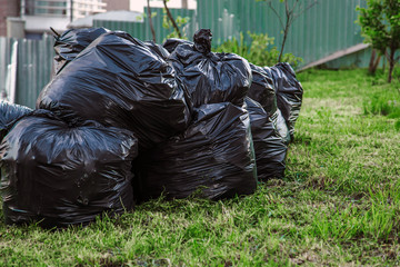 Heap garbage plastic bags many in the garden, pollution from trash bag waste. Pollution, trash.Nature ecology problem, threat of pollution, global warming, clean earth concept.