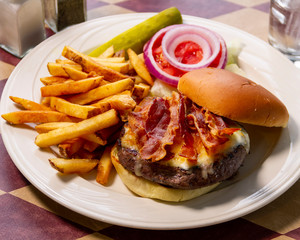 Bacon Cheeseburger and fries with a pickle