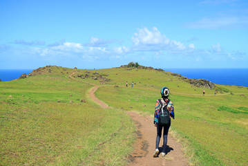Fototapeta premium Female Tourist Visiting Orongo Village, the Historic Ceremonial Center on Easter Island, Chile