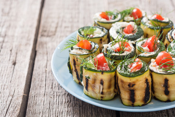 Zucchini rolls with cream cheese , tomatoes and dill