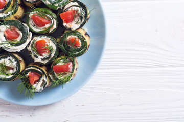Zucchini rolls with cream cheese , tomatoes and dill