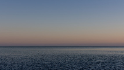 Quiet cozy evening at sea, purple sunset on the sea coast