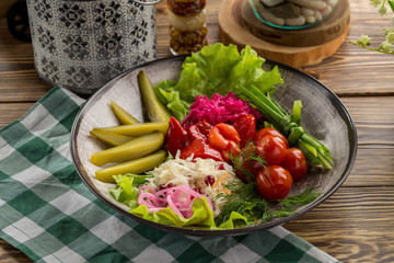 Pickled vegetables cucumber, tomato, pepper, cabbage Preserved food on wooden table