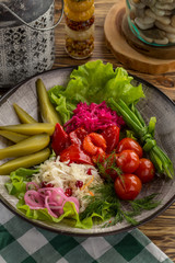 Pickled vegetables cucumber, tomato, pepper, cabbage Preserved food on wooden table