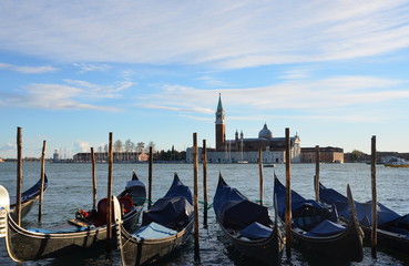 Fototapeta na wymiar group of Gondolas moored by Saint Mark's square with San Giorgio di Maggiore church in Venice, Italy, Europe