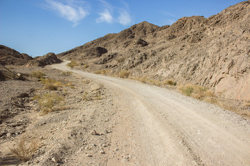 south warm desert wasteland scenery landscape with rural trail through mountains and hills wilderness environment 