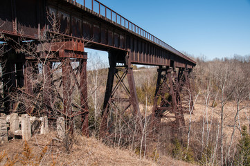 Fototapeta na wymiar Old dilapidated rusty steel railway bridge