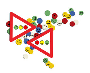 People in the city. Symbolic composition of multicolored circles with smilies on the background of a road sign and a traffic light.